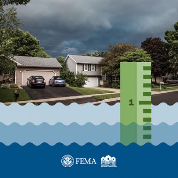 Ruler measuring flooding depth in font of suburban homes